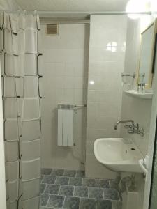 a white bathroom with a sink and a mirror at Family Hotel Santo Bansko in Bansko