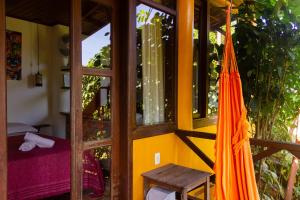 a room with an orange umbrella next to a window at Pousada Aquarela in Morro de São Paulo