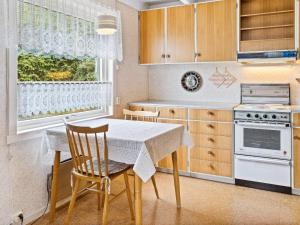 a kitchen with a table and chairs and a window at Holiday home Åram in Sandvik