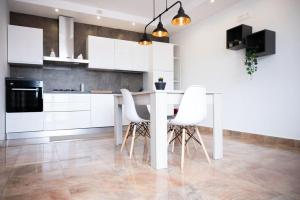 a kitchen with a white table and white chairs at Room 500 in Siano