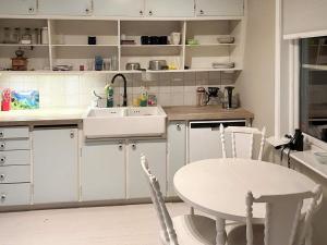 cocina con fregadero y mesa con sillas en Holiday home helgeroa, en Helgeroen