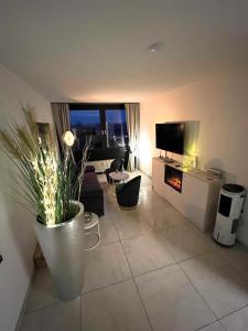 a living room with a large vase with a plant at Ferien-Whg Seeadler direkt am Meer, mit Meerblick in Steinhude