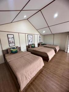 Zimmer mit 3 Betten in einem Zimmer in der Unterkunft Villa Takasima Berastagi in Berastagi