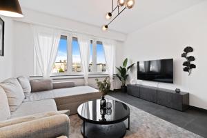 sala de estar con sofá y mesa en Charming 1BR Apt w/ Terrace & 5 min Drive to City, en Luxemburgo