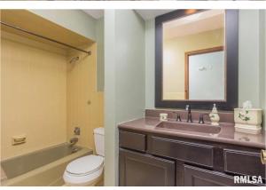 a bathroom with a sink and a toilet and a mirror at Luxurious condo Moline Quad Cities 4bedrooms 2 bath in Moline