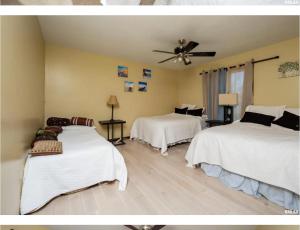 um quarto com 2 camas e uma ventoinha de tecto em Luxurious condo Moline Quad Cities 4bedrooms 2 bath em Moline