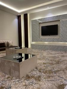 a living room with a television on a wall at شاليهات دار الورد in Taif