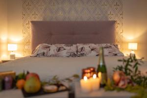 - une chambre avec un lit avec des bougies et une table avec des fruits dans l'établissement San Michele al Castello, à Castiglion Fiorentino