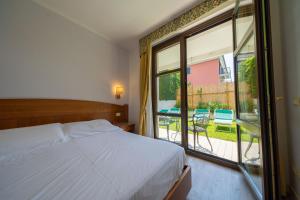 a bedroom with a bed and a large window at Hotel Smeraldo in Lazise