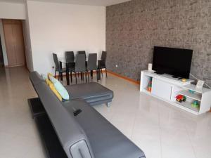 ein Wohnzimmer mit einem Sofa und einem Flachbild-TV in der Unterkunft Shared room in Praia in Praia