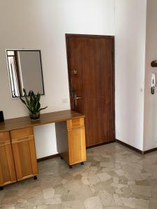 una stanza con una scrivania, uno specchio e una porta di Flat Seriate a Seriate
