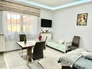 um quarto com uma cama, uma mesa e cadeiras em Gita Apartman em Makó