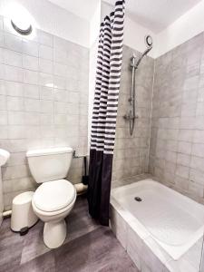 a bathroom with a toilet and a tub and a sink at 1- Studio Brides-les-bains tout confort in Brides-les-Bains