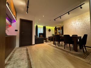 a dining room and living room with a table and chairs at Ice Dream Apartmani in Kopaonik