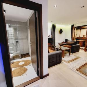 a living room with a glass door leading to a bathroom at Ice Dream Apartmani in Kopaonik