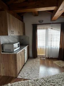 una cucina con forno a microonde su un bancone con finestra di Snow House a Bansko Altre 9 foto