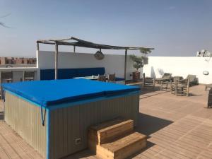 eine blaue Decke auf einem Dach mit einem Tisch und Stühlen in der Unterkunft HAUT de villa contemporain sur golf securise in Marrakesch