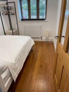 a bedroom with a bed and a wooden floor at Self contained 1 bedroom in Windsor