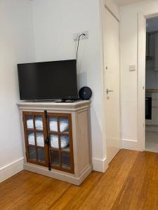 a flat screen tv on a cabinet in a room at Self contained 1 bedroom in Windsor