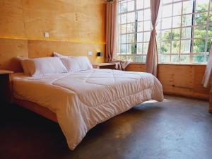 a bedroom with a large bed in front of a window at The Cascades Cabin Nakuru in Nakuru
