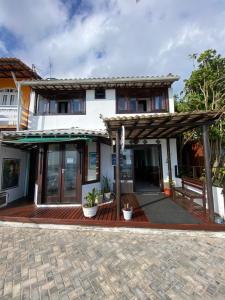 uma casa com um deque de madeira e um edifício em Pousada Maramar/terceira praia MSP em Morro de São Paulo