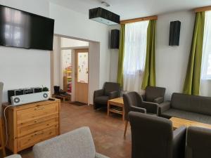 salon z kanapą, krzesłami i telewizorem w obiekcie Pension Janský Potok I. w Jańskich Łaźniach