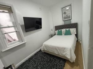 Un dormitorio con una cama y un televisor de pantalla plana. en Lovely Room 1Min Walk to Station with 55Inch TV, en Sídney