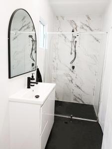 uma casa de banho branca com um lavatório e um espelho em Lovely Room 1Min Walk to Station with 55Inch TV em Sydney
