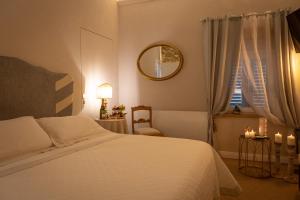 a bedroom with a bed and a mirror and a window at San Michele al Castello in Castiglion Fiorentino