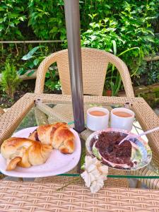 a table with two plates of food and a plate of bread at त्रिnity homestay in Kasol