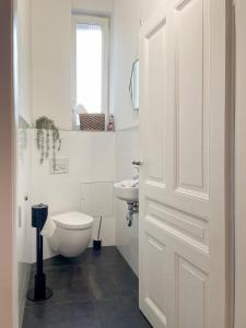 a white bathroom with a toilet and a sink at namastay! - Luxus mit Blick auf den Wasserturm in Mannheim