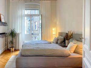 a bedroom with a large bed and a window at namastay! - Luxus mit Blick auf den Wasserturm in Mannheim