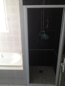 a bathroom with a shower and a tub and a sink at Chambre d'hôtes l'Amaryllis in Cournon-dʼAuvergne