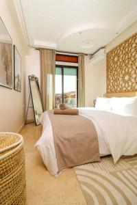 um quarto com uma cama grande e uma janela grande em En plein Cœur de Gueliz em Marraquexe