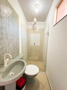 een badkamer met een wastafel, een toilet en een douche bij Flat Completo no Centro de Itacaré in Itacaré