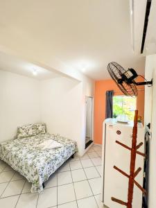 een kamer met een bed en een koelkast. bij Flat Completo no Centro de Itacaré in Itacaré