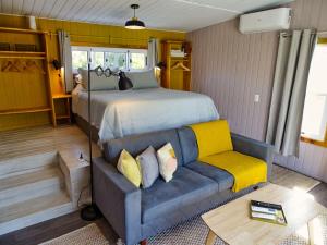 um quarto com uma cama grande e um sofá em Il Tano Suites em Punta Del Diablo