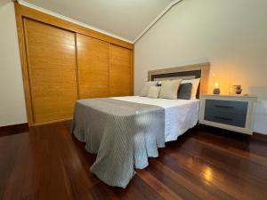 una camera con un grande letto e una parete in legno di Fantástico Dúplex Vista Bahia a El Astillero