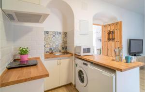 a kitchen with a washing machine and a microwave at Nice Apartment In Arcos De La Frontera in Arcos de la Frontera
