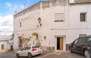 two cars parked in front of a white building at Nice Apartment In Arcos De La Frontera in Arcos de la Frontera