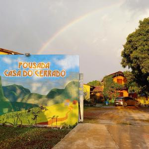 um arco-íris está no céu sobre um sinal em Pousada Casa do Cerrado - Alto Paraíso de Goiás em Alto Paraíso de Goiás