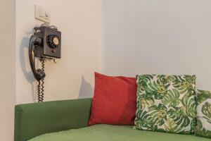 a green couch with a red pillow and a phone at Extravacanza Central Station in Bari