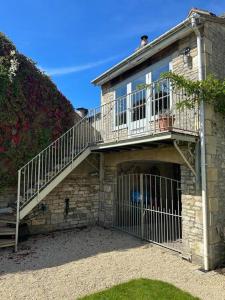 a stone house with a staircase and a balcony at The Loft House in Hinton Charterhouse