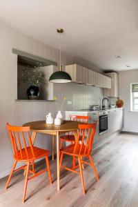 uma cozinha com uma mesa e 2 cadeiras e uma cozinha com um fogão em The Loft House em Hinton Charterhouse