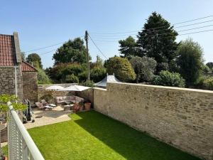 a garden with a brick wall and green grass at The Loft House in Hinton Charterhouse