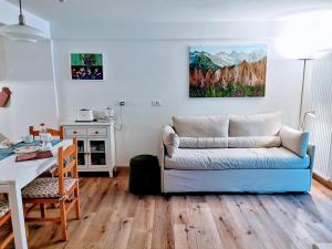 ein Wohnzimmer mit einem blauen Sofa und einem Tisch in der Unterkunft Casina Alpina sugli impianti Passo S Pellegrino in Passo San Pellegrino