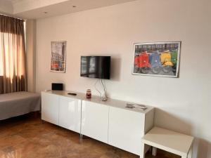 a living room with a bed and a tv on a wall at Room 500 in Siano