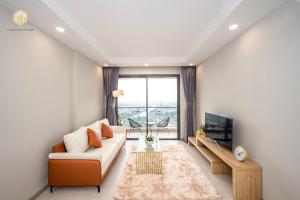 a living room with a couch and a tv at The Gold View D4 - Canhogiatot24h in Ho Chi Minh City