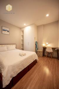 a bedroom with a large bed and a desk at Cozy Apartment, City Center , The Goldview D4 in Ho Chi Minh City