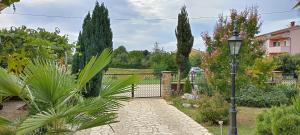 d'un jardin avec une porte et un éclairage de rue. dans l'établissement Adriana Holiday house Nova Vas, à Nova Vas